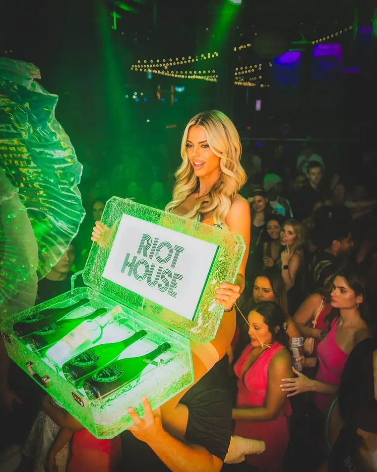Bottle service presentation, champagne in a lit ice case carried through the crowd