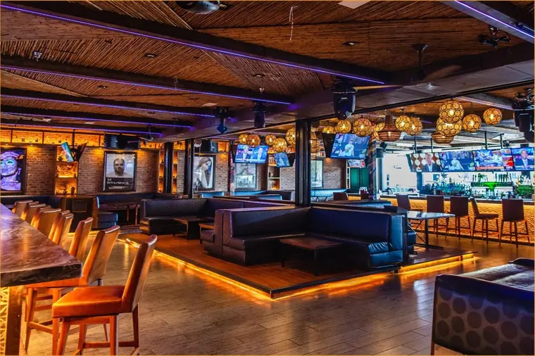 Warm wood lounge with leather banquettes and amber under-lighting