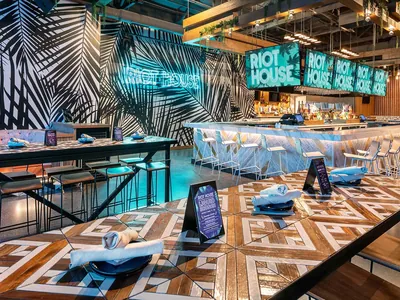 Riot House bar under a black and white palm mural